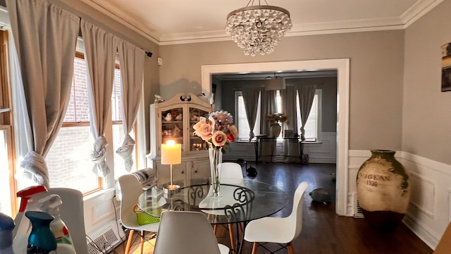 dining space featuring ornamental molding, dark hardwood / wood-style floors, and a notable chandelier