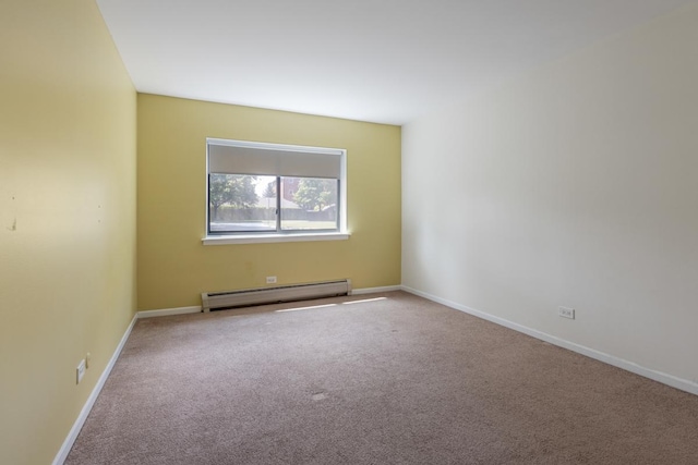 spare room featuring carpet floors and a baseboard heating unit