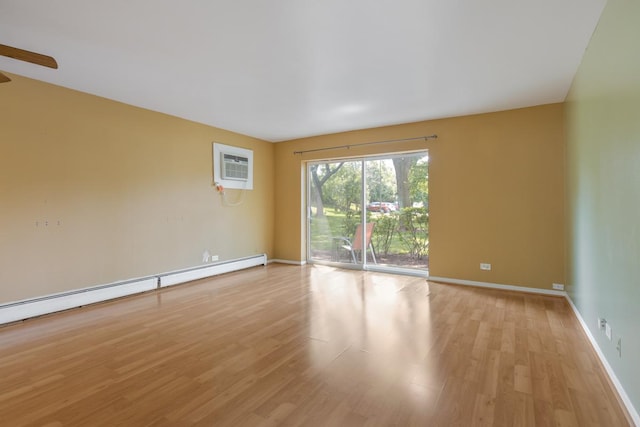 empty room with a baseboard radiator, light wood-type flooring, and an AC wall unit