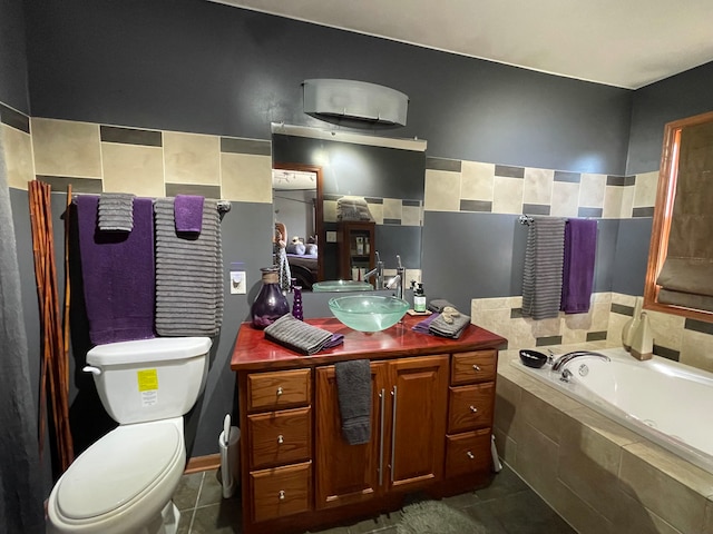 bathroom with vanity, a relaxing tiled tub, toilet, and tile patterned floors