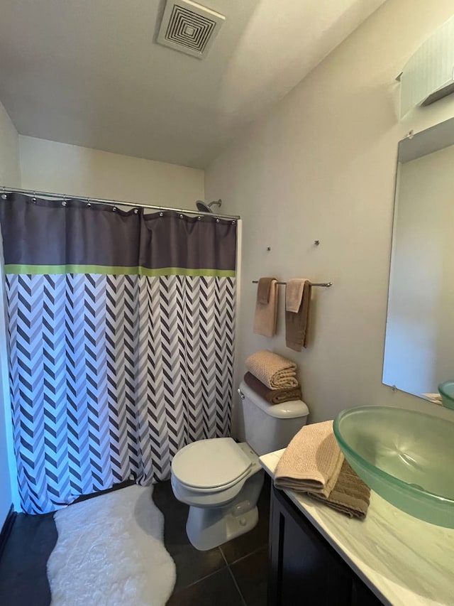 bathroom featuring walk in shower, vanity, toilet, and tile patterned floors