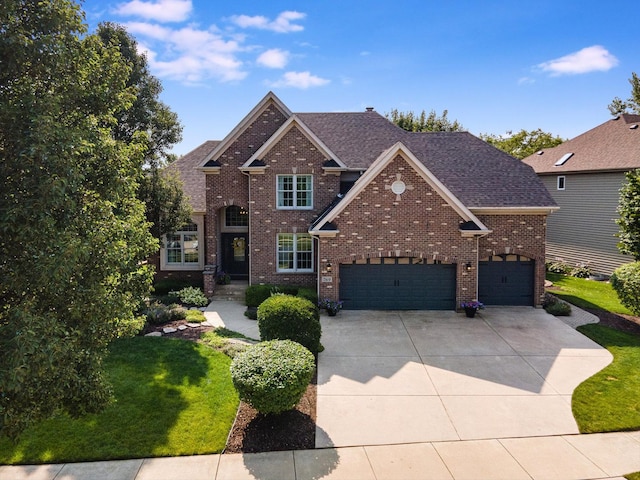 traditional-style house with a garage, concrete driveway, a shingled roof, and brick siding