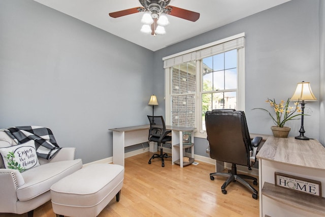 office area with light wood-type flooring, ceiling fan, and baseboards