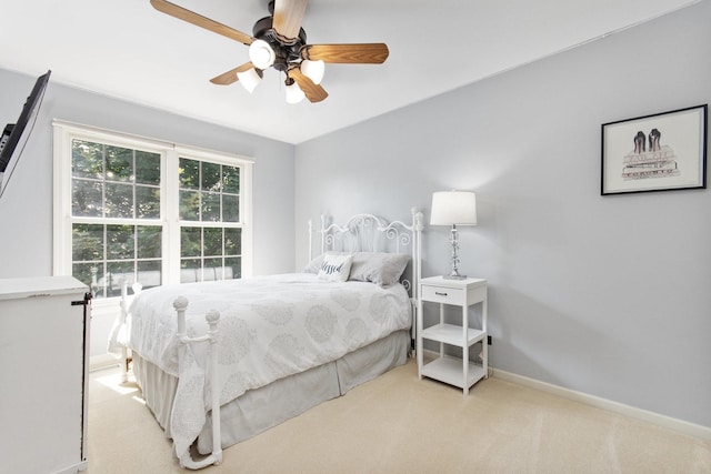 bedroom with light carpet, ceiling fan, and baseboards