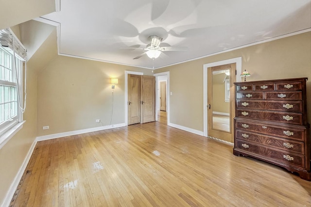 unfurnished bedroom featuring ceiling fan, light wood-type flooring, and crown molding