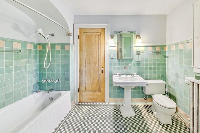 bathroom with shower / bathing tub combination, tile walls, and toilet