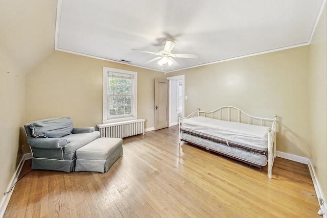 bedroom with light wood-type flooring, radiator, crown molding, and ceiling fan