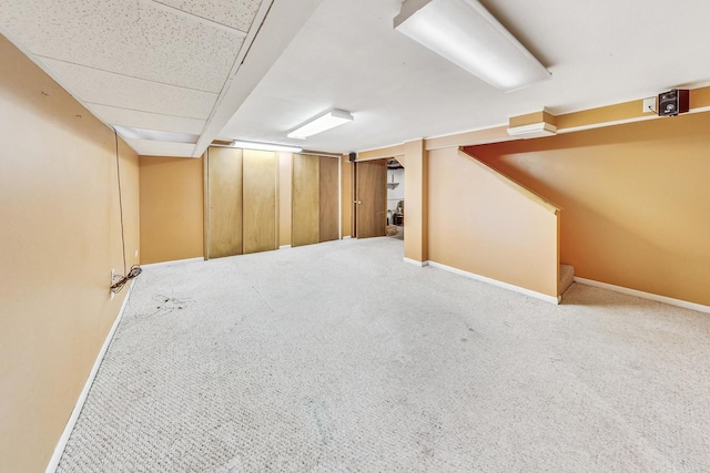 basement with carpet flooring and a drop ceiling