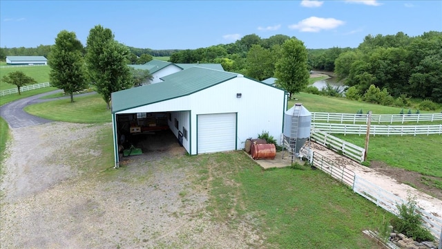 view of outbuilding with a garage, a lawn, and a water view