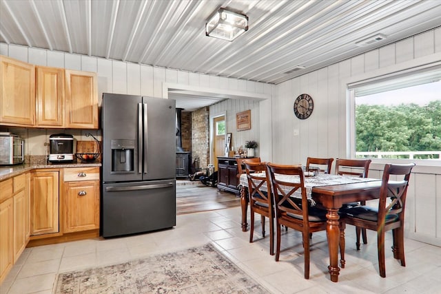 tiled dining area featuring a wood stove