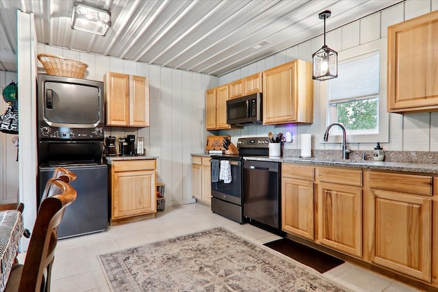 kitchen with stacked washer and dryer, sink, hanging light fixtures, stainless steel appliances, and light stone counters