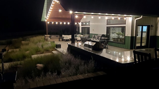 patio at night featuring outdoor lounge area