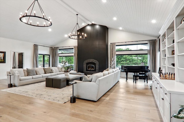 living room featuring high vaulted ceiling, a wealth of natural light, a fireplace, and light hardwood / wood-style floors