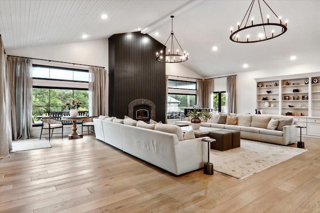 living room featuring an inviting chandelier, high vaulted ceiling, light wood-type flooring, a large fireplace, and beam ceiling