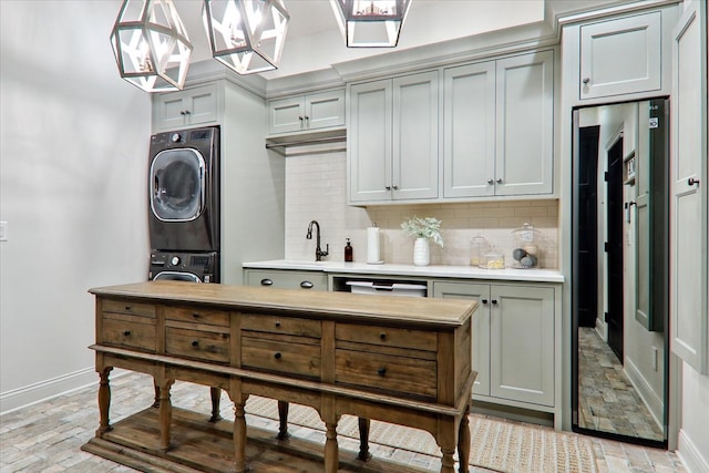 kitchen featuring pendant lighting, stacked washer and dryer, wall oven, and tasteful backsplash