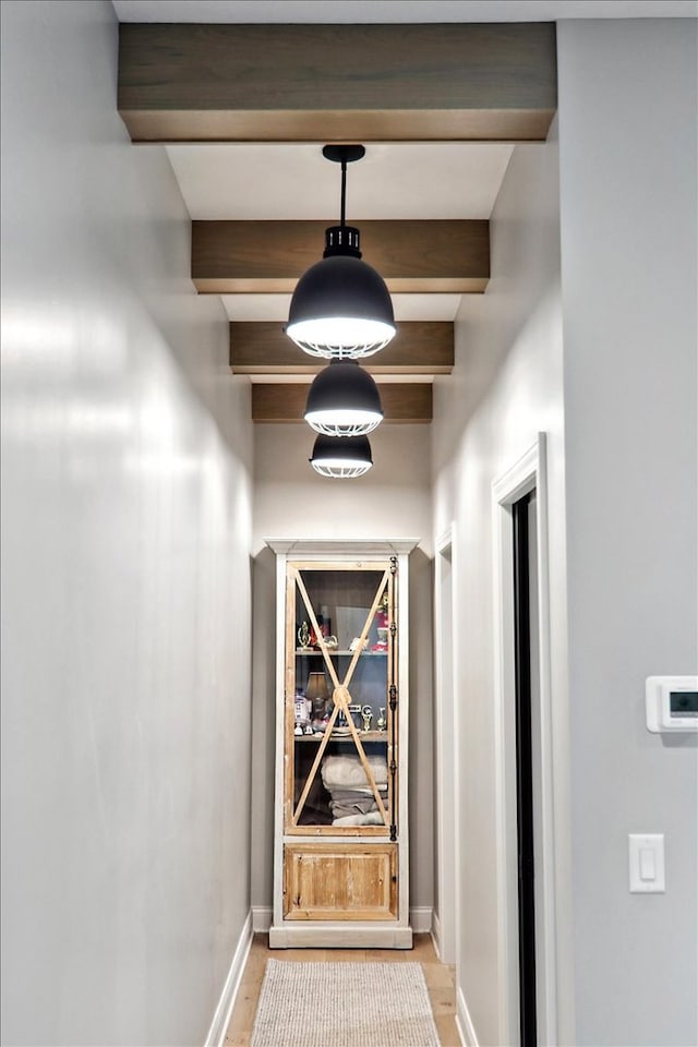 hall featuring beamed ceiling and light wood-type flooring