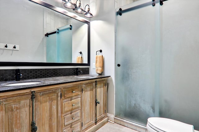 bathroom with vanity, toilet, an enclosed shower, and decorative backsplash