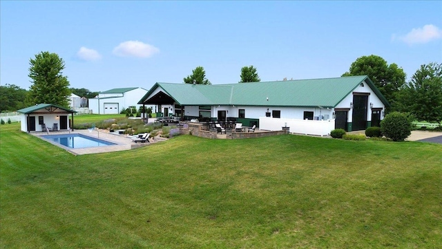 rear view of property with a yard, an outbuilding, and a patio area