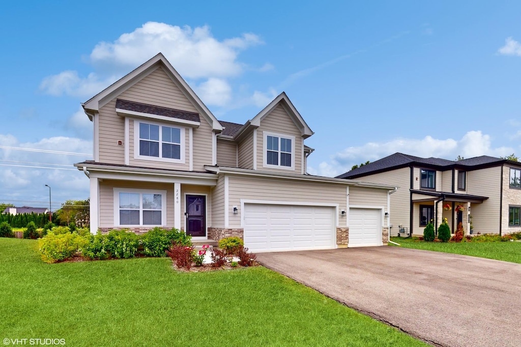 21379 W Sylvan Dr, Mundelein, IL 60060 - view of front of home with driveway, a front yard, and stone siding