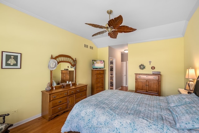 bedroom with ornamental molding, light hardwood / wood-style flooring, ceiling fan, and vaulted ceiling