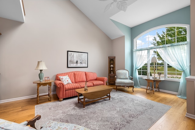 living room with ceiling fan, light hardwood / wood-style flooring, high vaulted ceiling, and plenty of natural light