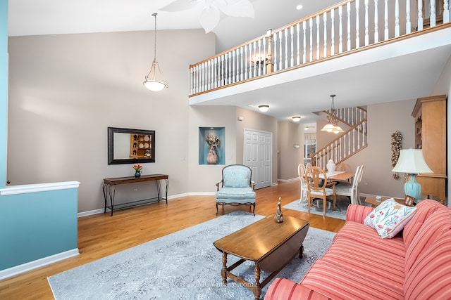 living room featuring ceiling fan, light hardwood / wood-style floors, and high vaulted ceiling