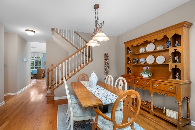 dining room with light hardwood / wood-style floors and an inviting chandelier