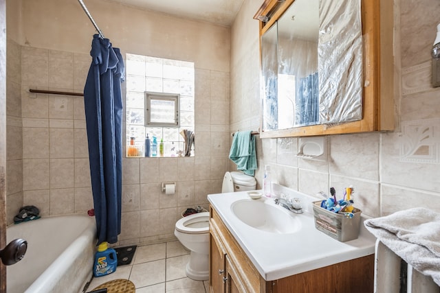 full bathroom featuring shower / bath combination with curtain, toilet, vanity, tile walls, and tile patterned floors