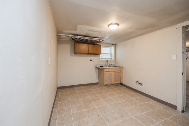 basement featuring light tile patterned flooring and sink