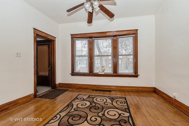 empty room with ceiling fan, light hardwood / wood-style flooring, and crown molding