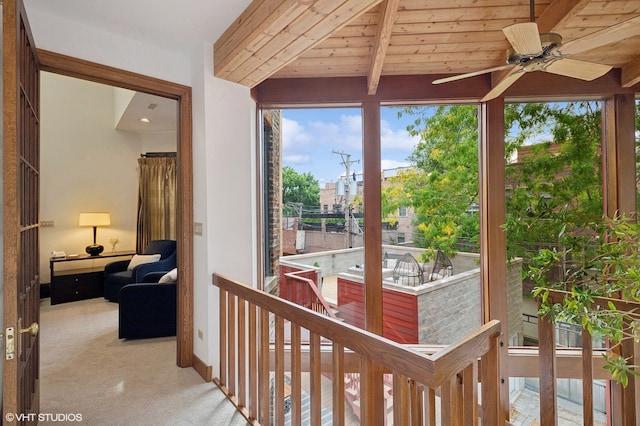 sunroom / solarium featuring wood ceiling, lofted ceiling with beams, ceiling fan, and a wealth of natural light