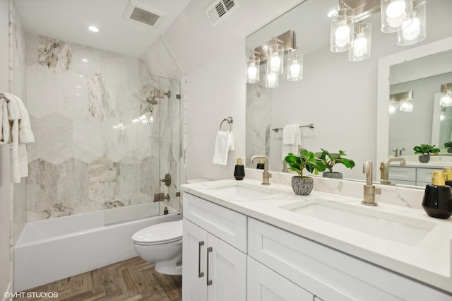 full bathroom featuring vanity, parquet floors, tiled shower / bath, and toilet