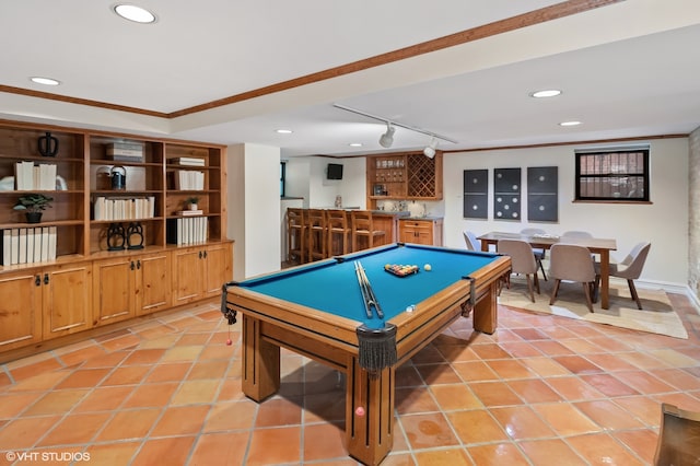 game room featuring rail lighting, light tile patterned floors, crown molding, pool table, and bar area