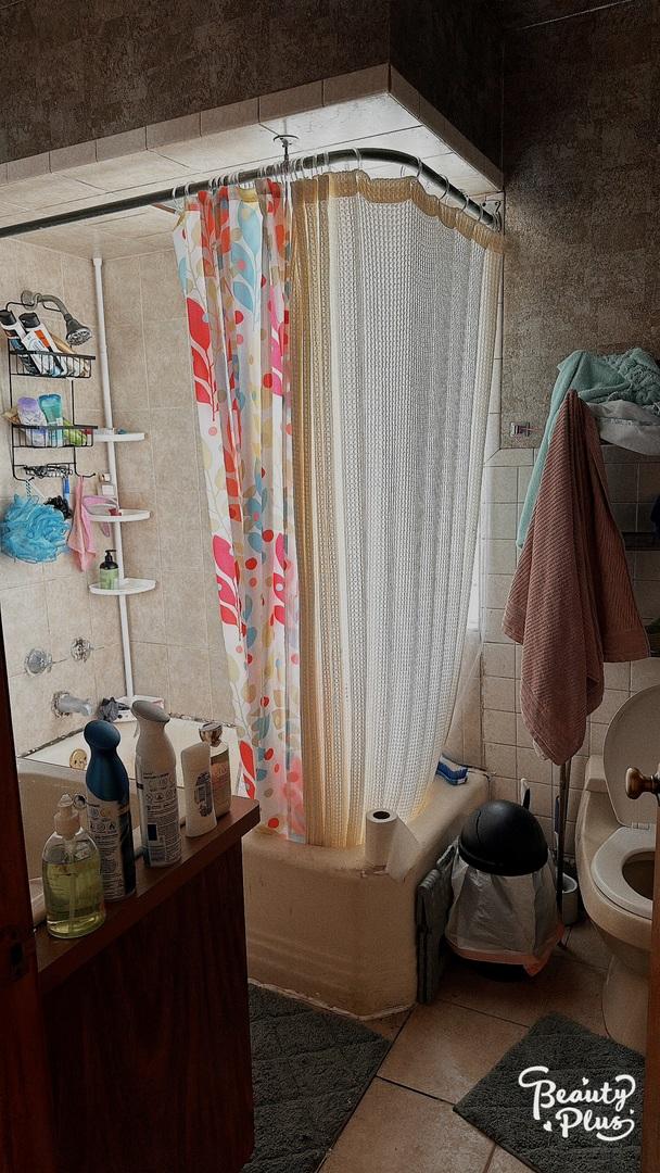 bathroom featuring toilet, tile patterned floors, and shower / bath combo with shower curtain