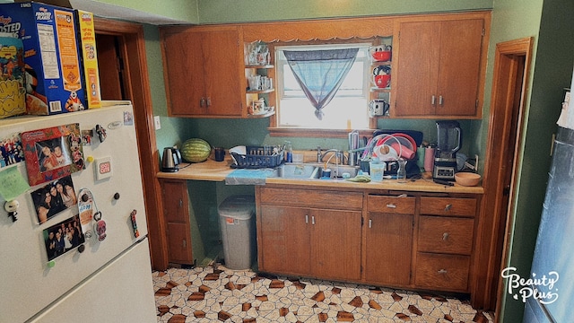 kitchen with sink and white fridge