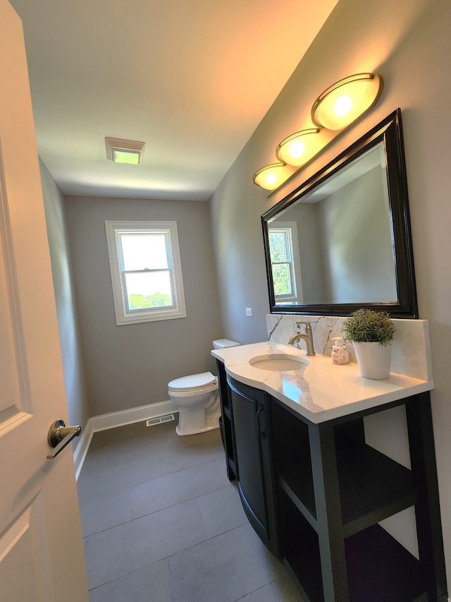 bathroom with tile patterned flooring, decorative backsplash, toilet, and vanity