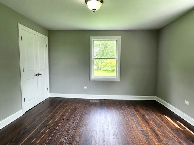 unfurnished room featuring dark wood-type flooring