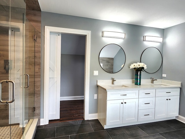 bathroom featuring tile patterned flooring, dual vanity, and an enclosed shower