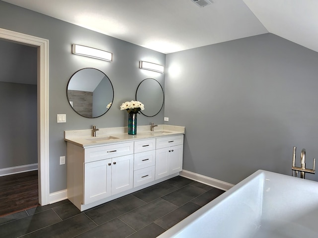 bathroom with wood-type flooring, double sink vanity, and lofted ceiling