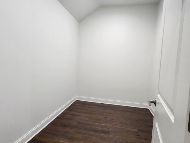 empty room featuring wood-type flooring and vaulted ceiling