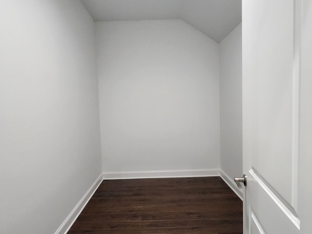 spare room with dark hardwood / wood-style flooring and vaulted ceiling