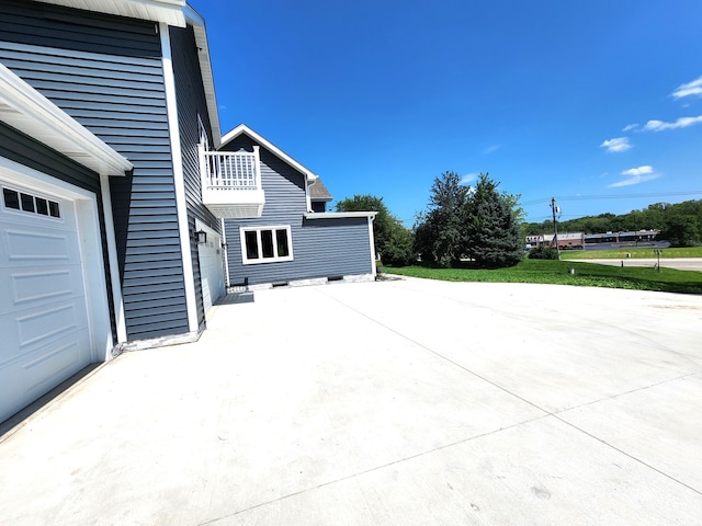 view of patio / terrace with a garage and a balcony