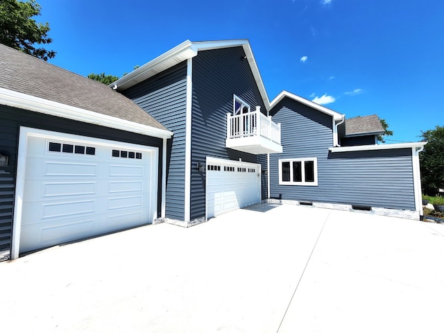 view of side of home with a balcony and a garage