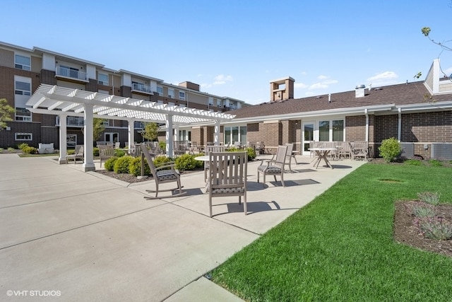 exterior space featuring a pergola, a patio area, and a lawn