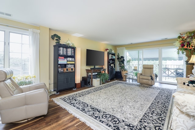 living room featuring a wealth of natural light and dark hardwood / wood-style flooring