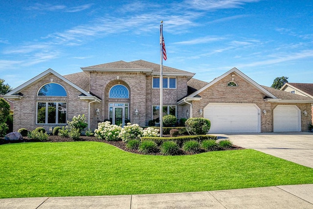 view of front of home featuring a garage, driveway, brick siding, and a front yard