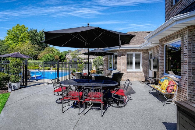 view of patio / terrace featuring outdoor dining area, fence, and a fenced in pool