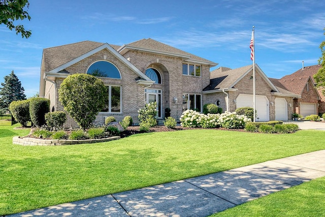 view of front of property with an attached garage, brick siding, a shingled roof, concrete driveway, and a front yard