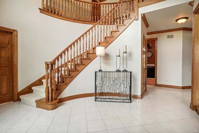 stairs with baseboards, ornamental molding, visible vents, and tile patterned floors