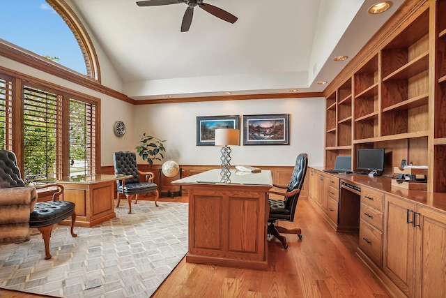 home office with lofted ceiling, a wainscoted wall, a ceiling fan, light wood-style floors, and built in study area